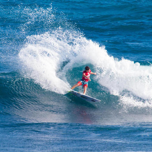 Surfer riding a wave with splashing water.