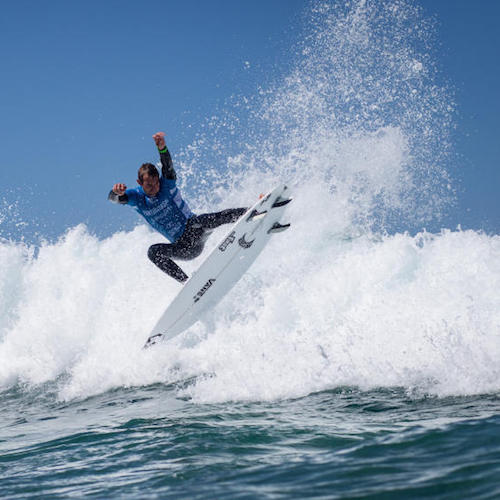 Surfer performing a jump over a wave.