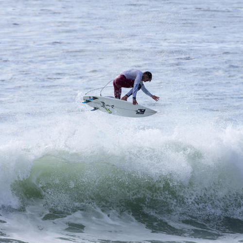 Surfer performing a jump over a wave.