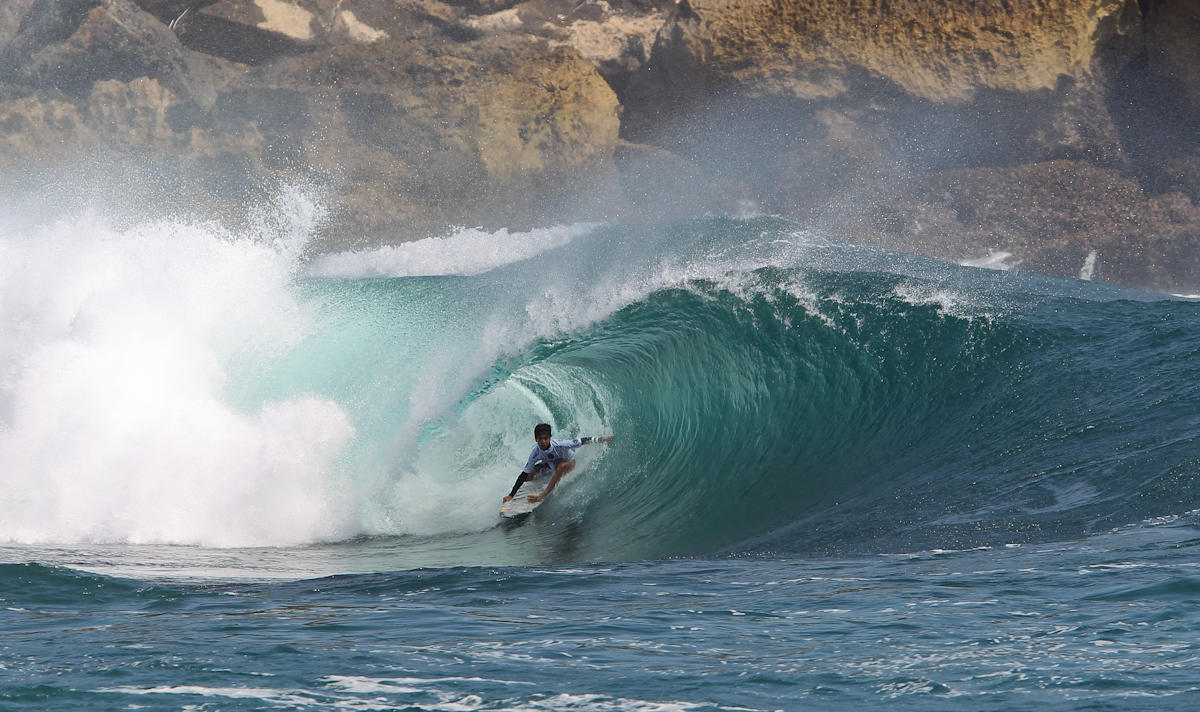 Surfer riding a large wave in the ocean.