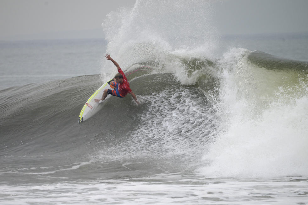 Surfer performing a maneuver on a large wave.
