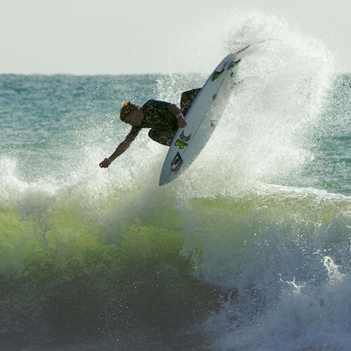 Surfer performing a jump over a wave.