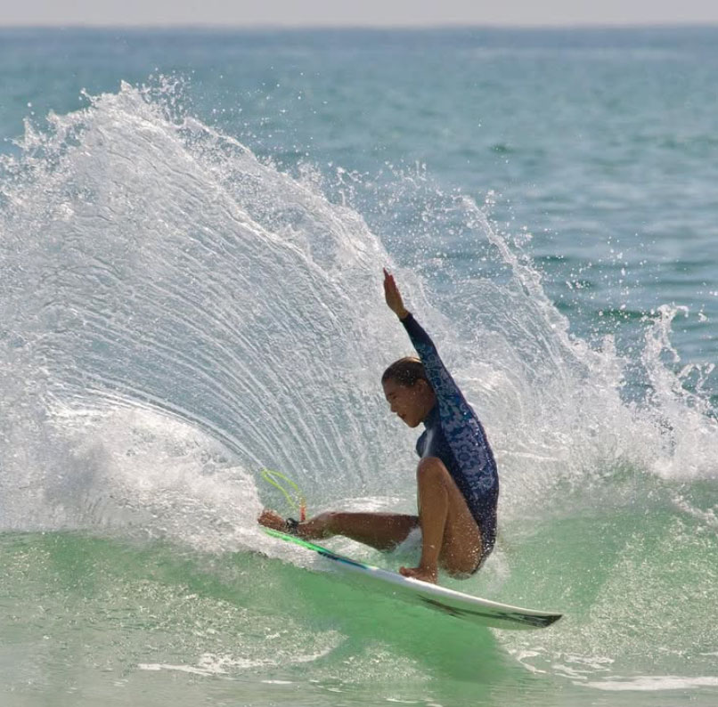 Surfer performing a maneuver on a wave.