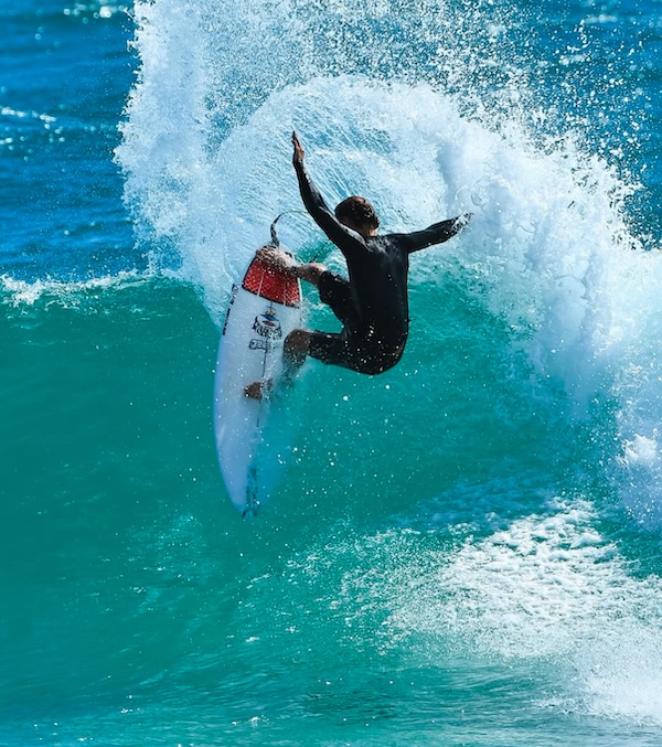 Surfer performing a trick on a large wave.