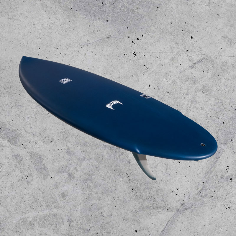 A blue surfboard with a smooth finish and a single fin, positioned against a textured gray background. The board features logos on its surface.