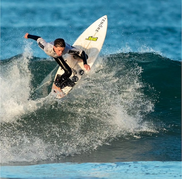 Surfer performing a maneuver on a wave.