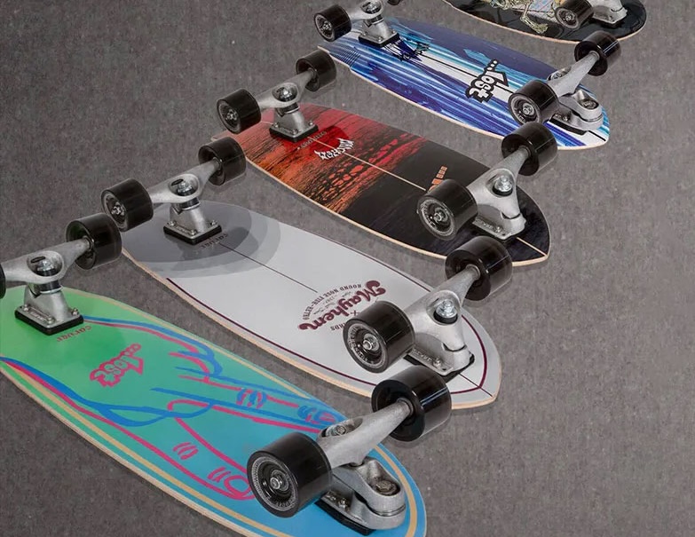 Multiple skateboards arranged in a line with various designs.