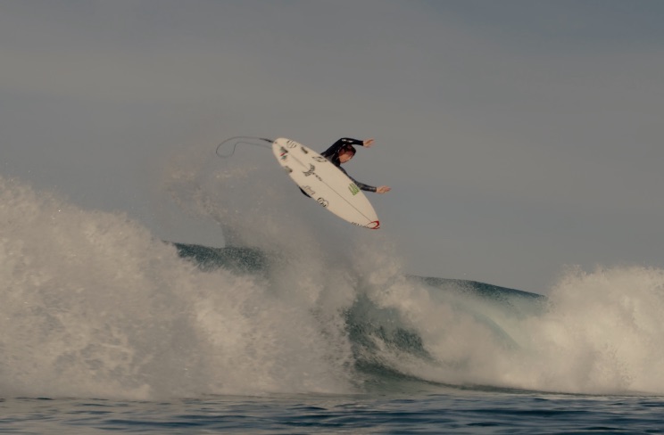 Surfer performing a jump over a wave.