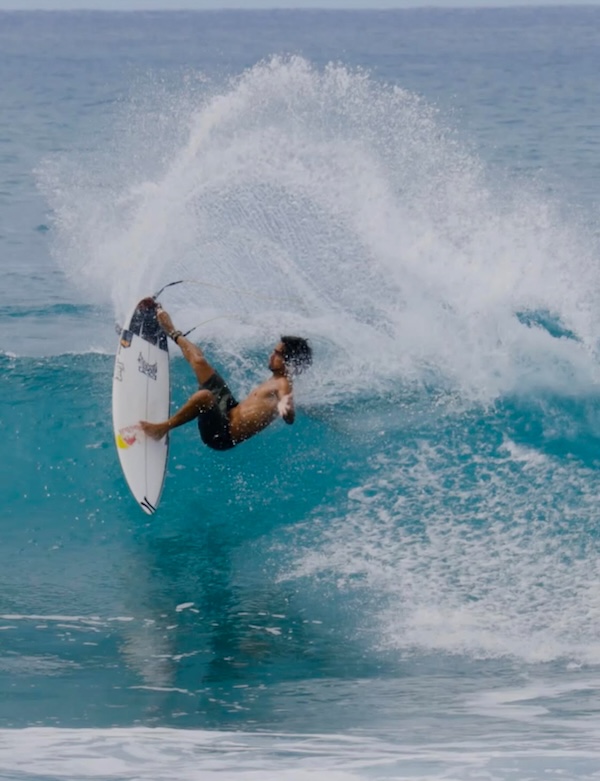 Surfer performing a maneuver on a wave.