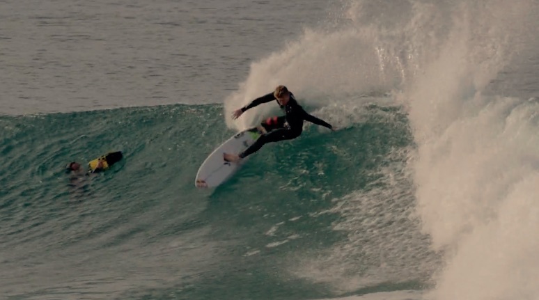 Surfer riding a wave with another person in the water.
