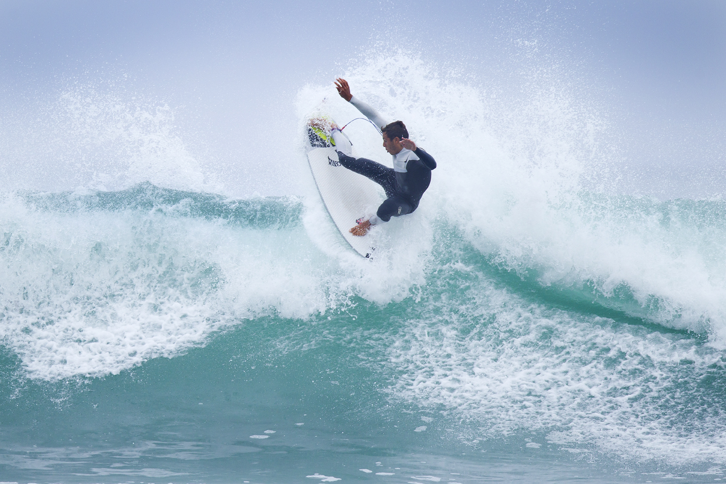 Surfer performing a maneuver on a wave.
