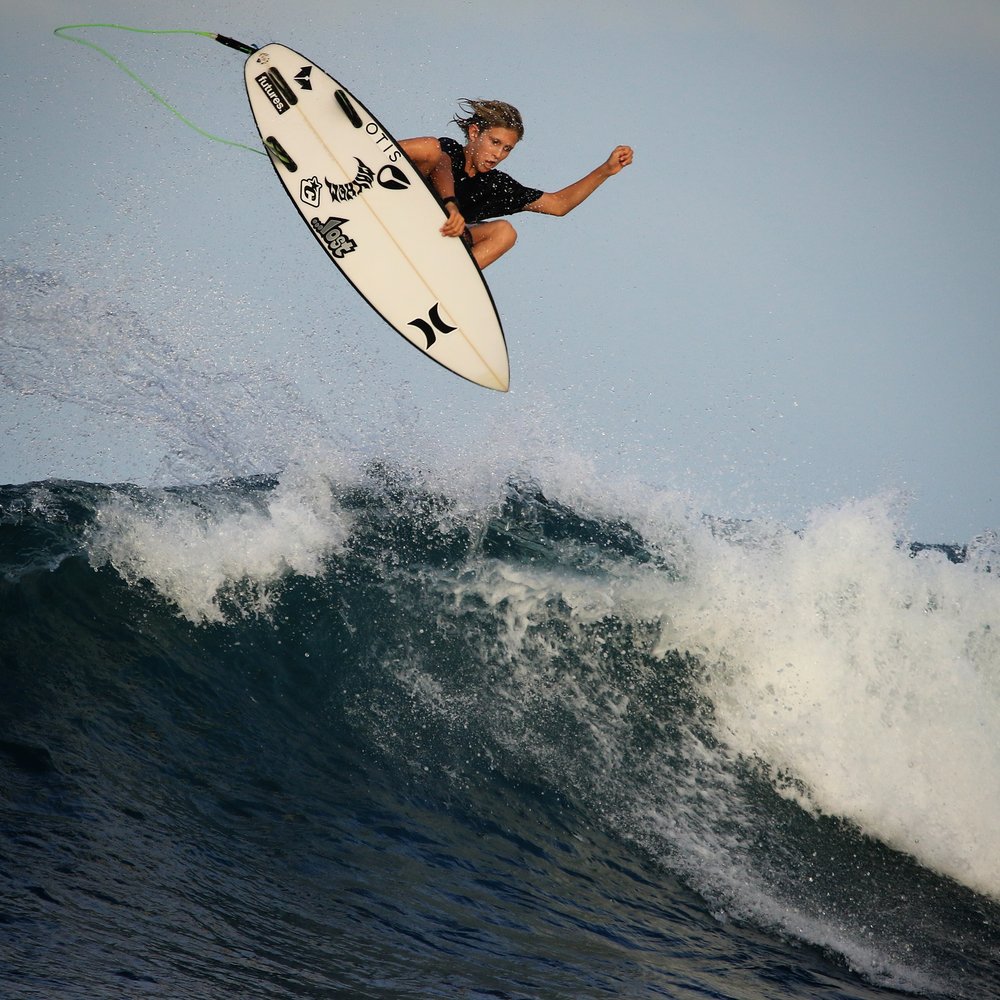 Surfer performing a jump over a wave.