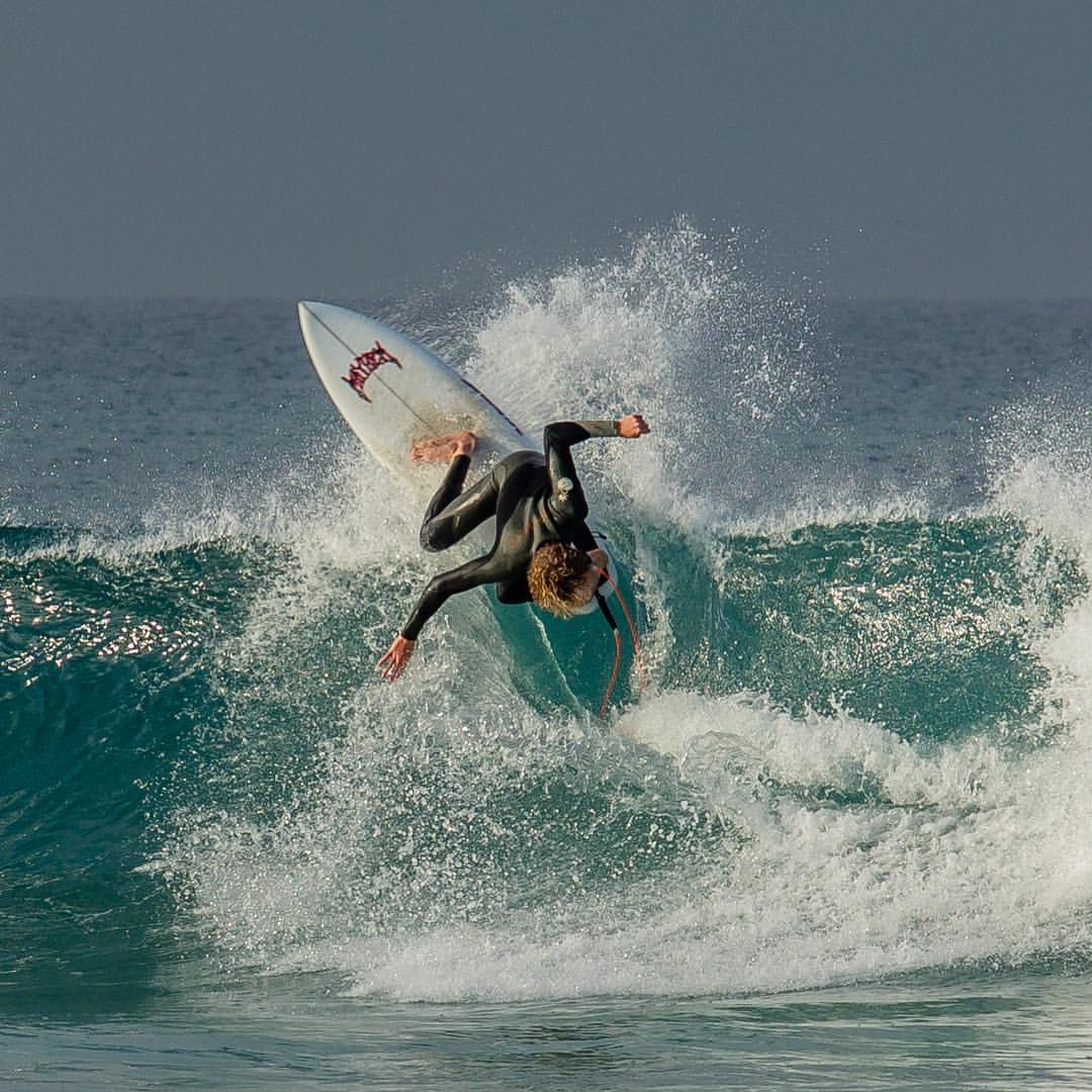 Surfer performing a maneuver on a wave.
