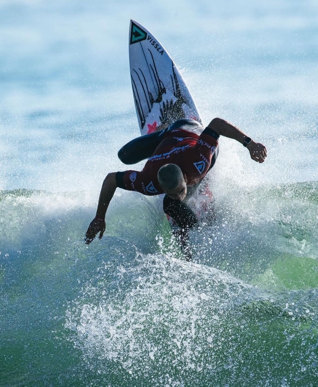 Surfer performing a maneuver on a wave, splashing water.