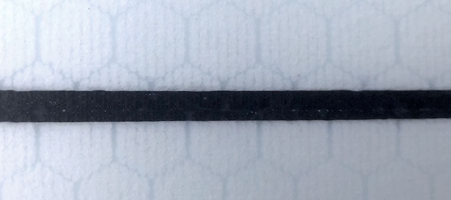 Black carbon stringer on a textured white background.