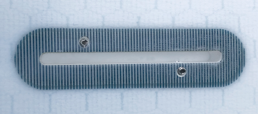 Surfboard fin box with striped design and mounting screws.