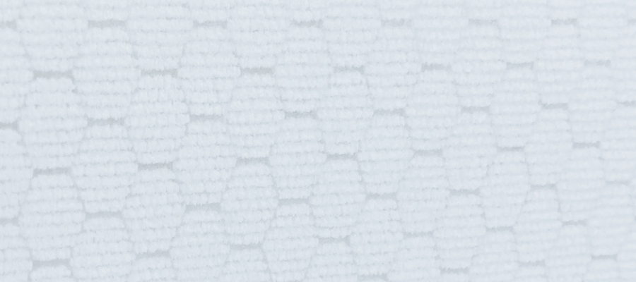 Close-up of textured white fabric with hexagonal pattern.