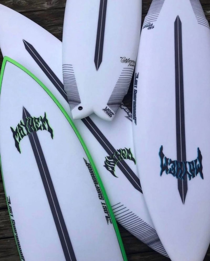 Multiple surfboards stacked together on a wooden surface.