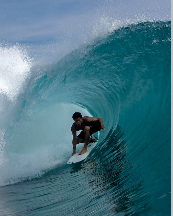 Surfer riding a wave inside a barrel.