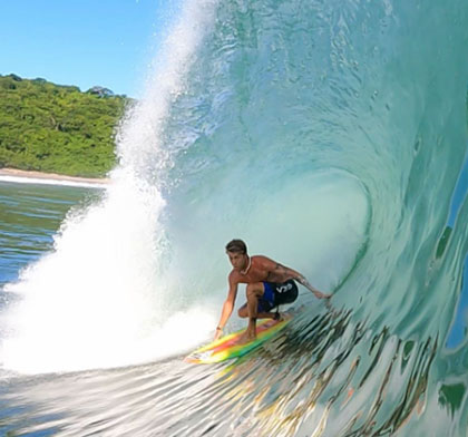 Surfer riding a wave inside a barrel.
