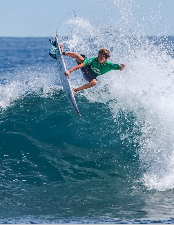 Surfer performing a trick on a wave.