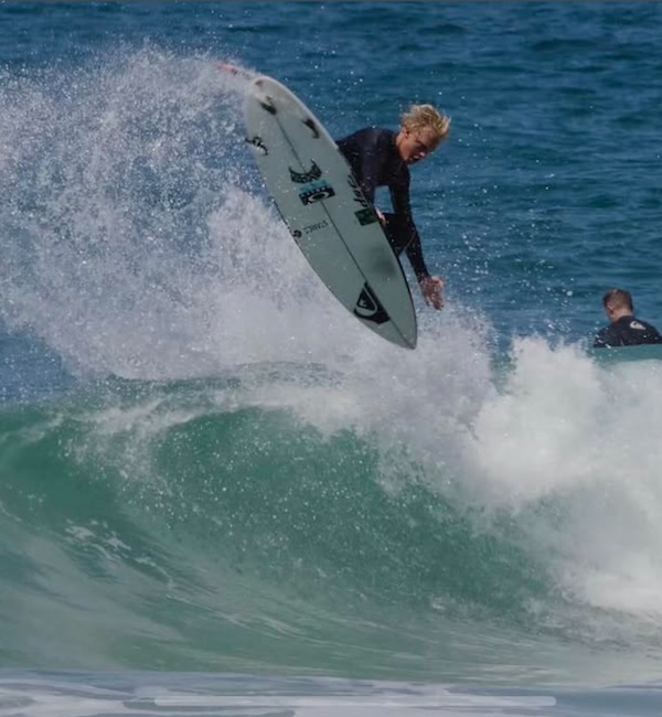 Surfer performing a jump over a wave.