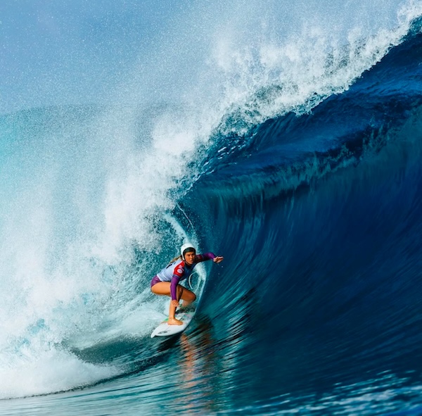 Surfer riding a large wave in the ocean.
