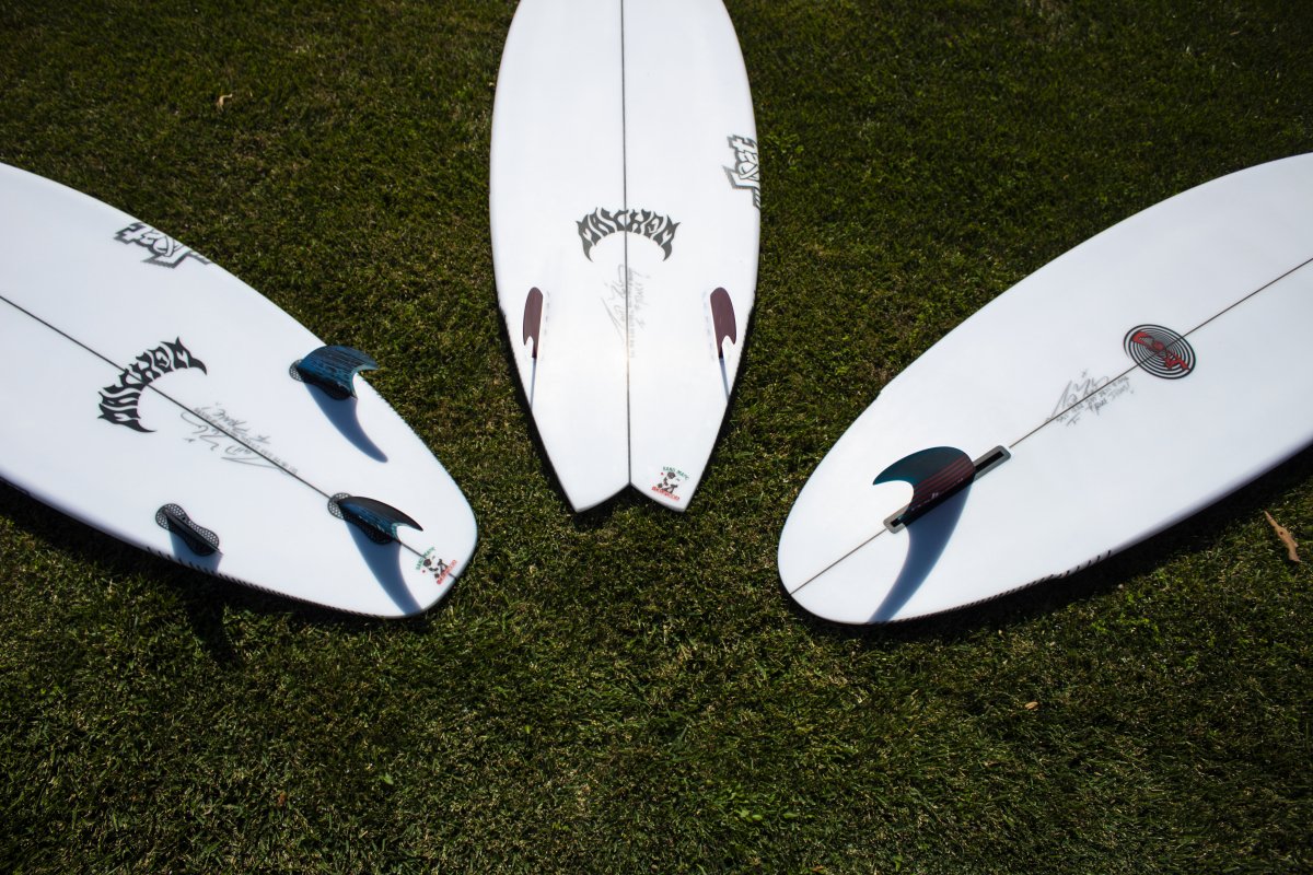 Three surfboards arranged on green grass.