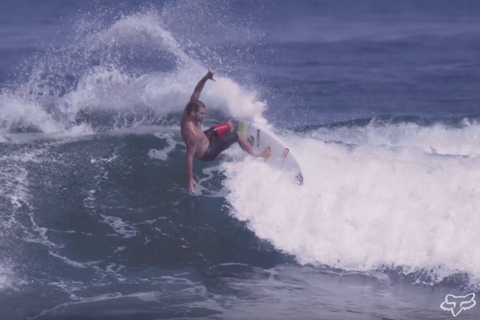 Surfer performing a maneuver on a wave.