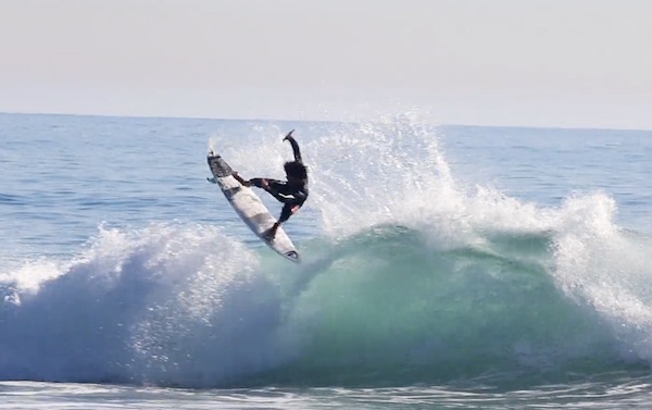 Surfer performing a maneuver on a large wave.