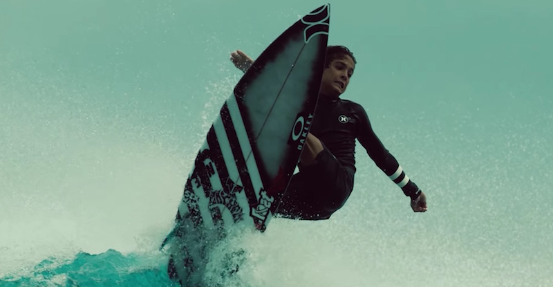 Surfer performing a trick on a wave with spray.