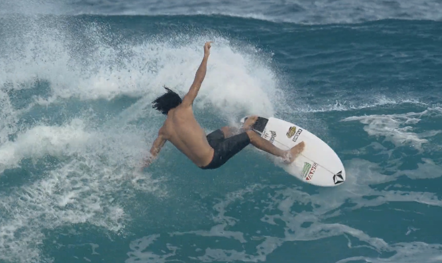 Surfer performing a maneuver on a wave in the ocean.