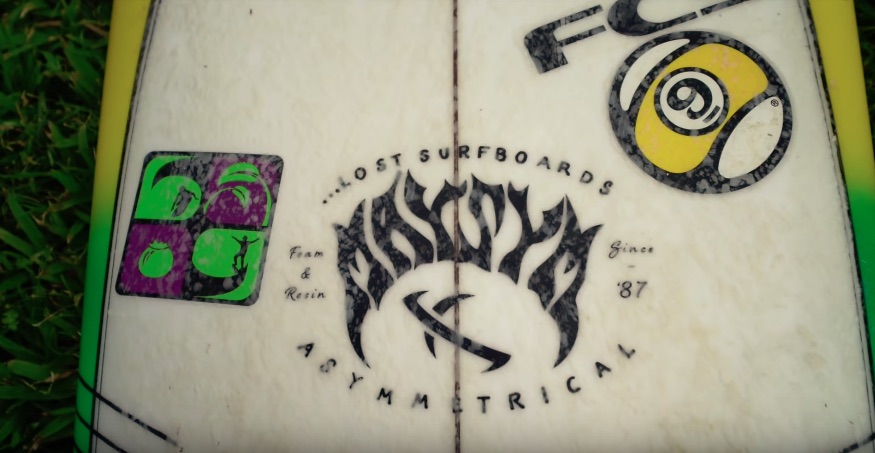 Close-up of a surfboard with logos and designs.