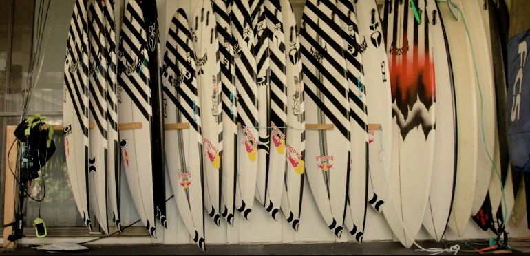 Row of surfboards with black and white designs on display.