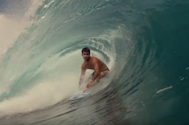 Surfer riding a wave inside a barrel.