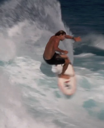 Surfer performing a maneuver on a wave.