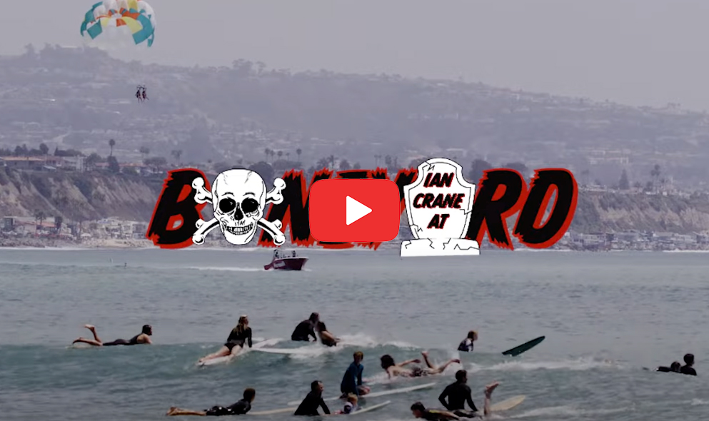 Surfers in the ocean with a parasailer above and text overlay.