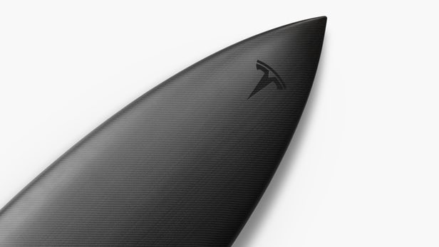 Black surfboard with Tesla logo on the tip.