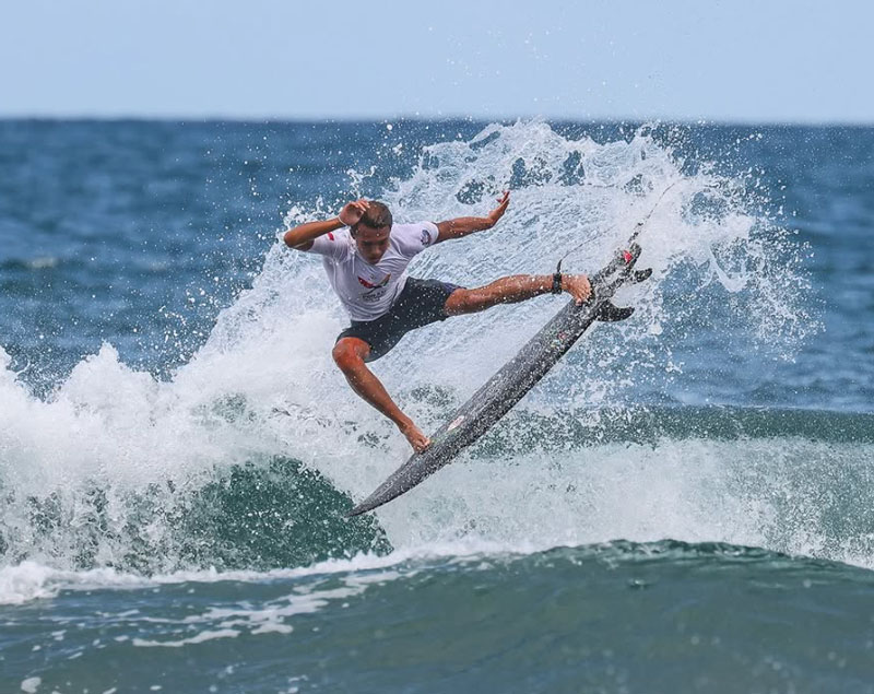 Surfer performing a trick on a wave.