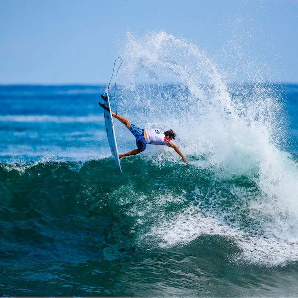 Surfer performing a trick on a large wave.