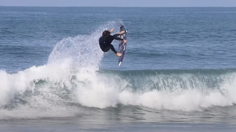Surfer performing a jump over a wave.