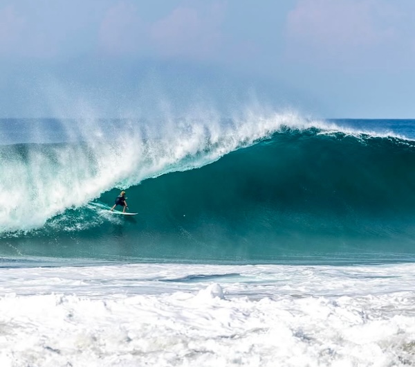 Surfer riding a large wave at Zion beach.