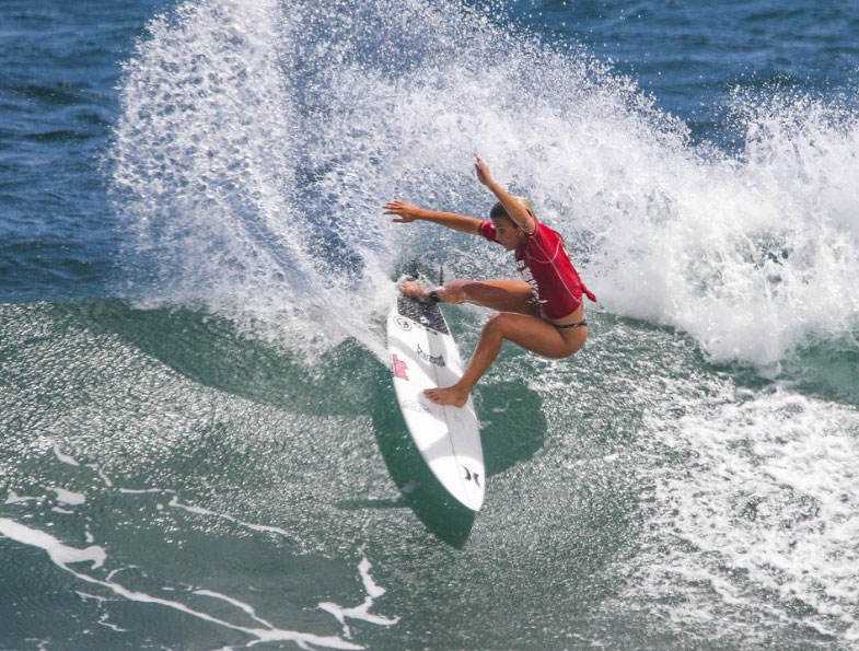 Surfer performing a maneuver on a wave.