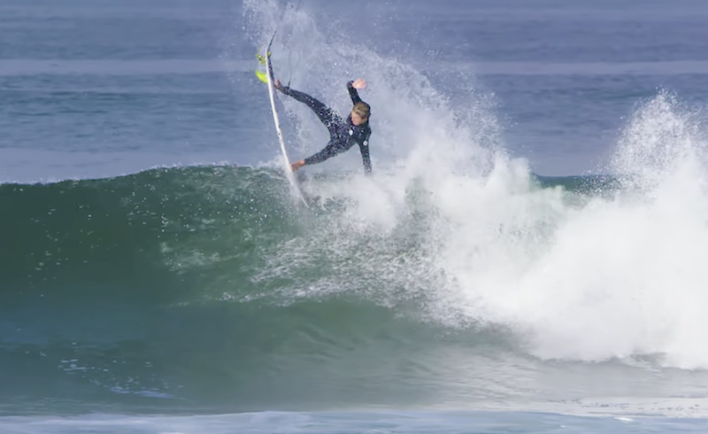 Surfer performing a maneuver on a wave.