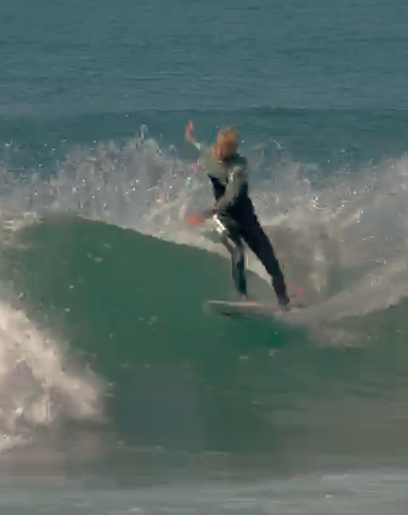 Surfer riding a wave, splashing water around.