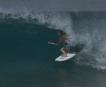 Surfer riding a wave, partially covered by water spray.